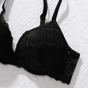 Close-up detail of a black push-up bra showing the intricate floral lace patterns.
