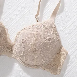 Close-up detail of elegant beige floral lace embroidery on a soft push-up bra cup