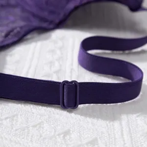 Close-up detail of a professional purple lace bra shoulder strap with an adjustable buckle