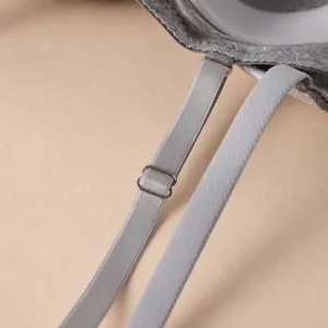 Close-up of adjustable gray bra strap with metallic slider and letter print band