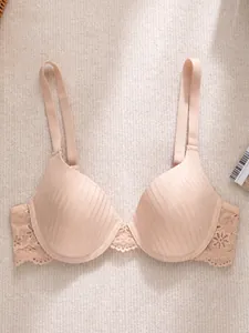 Close-up view of elegant nude lace push-up bra featuring vertical striped texture on cups