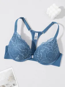 Macro detail of a blue lace bra featuring front closure and stylish racerback design