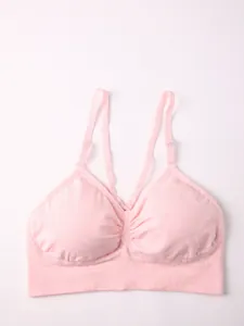 Nahaufnahme eines rosa nahtlosen Sport-BHs mit schmalen Trägern und geraffter Front.