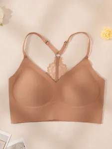 Detailansicht eines nahtlosen hautfarbenen Push-up-BHs mit filigranem Spitzenrücken-Design
