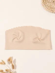 Primer plano de un sujetador tipo bandeau sin costuras en color nude con bordes