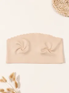 Close-up detail of a nude seamless ice silk bandeau bra featuring scalloped top edges