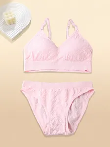 Detail of pink wireless lingerie set featuring adjustable straps and textured fabric