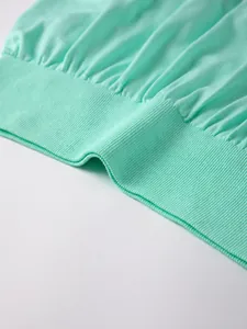 Detalle macro de la cintura elástica acanalada y textura de la falda de yoga verde menta