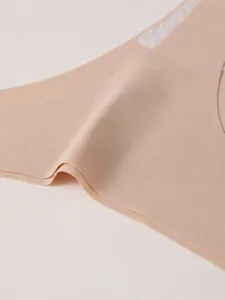 Detail shot of beige seamless ice silk thong with smooth elastic waistband texture
