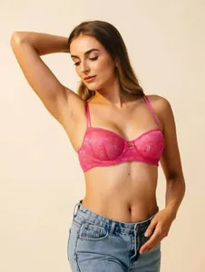 Gros plan détaillé d'un joli soutien-gorge push-up en dentelle rose à motifs floraux.