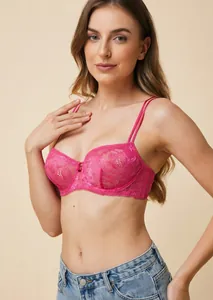 Détail d'un soutien-gorge push-up en dentelle rose à fines bretelles porté