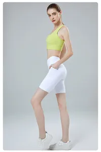 Detail view of lime green sports bra and white high-waisted yoga shorts with side pockets
