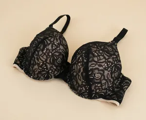 Detail shot showing the intricate black floral lace pattern on a nude push-up bra.