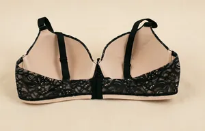 Detail view of lace bra featuring black floral pattern and beige inner lining design.
