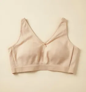 Detail van een naadloze beige draadloze beha voor grote maten met klein strikje