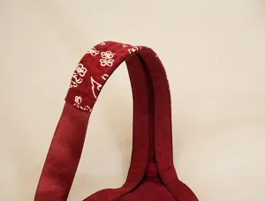 Close-up of wide shoulder strap with white floral print on a burgundy plus size bra.
