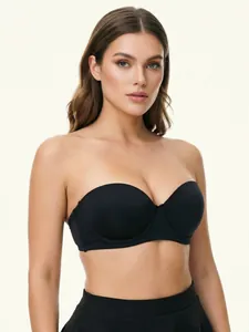 Detailed view of a black wireless strapless bandeau bra worn by a model in a studio