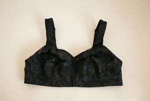 Macro view of delicate black floral lace embroidery on a plus-size wireless bra