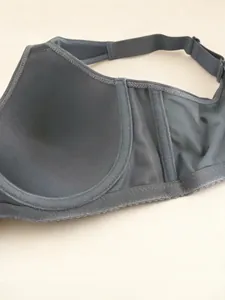 Close-up detail showing the seamless wing and inner cup of a dark gray thin cup bra