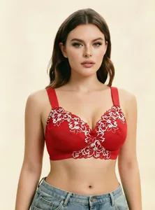 Detalle de sujetador rojo de talla grande con bordado floral blanco y tirantes anchos