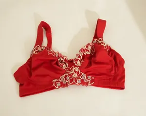 Vista detallada de un sujetador rojo sin aros de copa completa con bordado de flores.