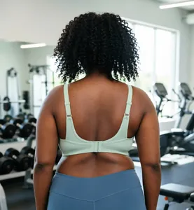 Achteraanzicht van een plus size mintgroene sportbeha gedragen in een fitnessruimte