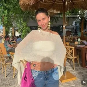 Detailed lifestyle view of a cream boho hollow knit beach cover-up poncho on a model outdoors