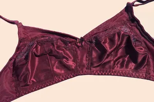 Detailed macro view of a burgundy C-cup wireless bra featuring ultra-thin lace patchwork