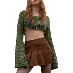 Detail of a green mesh crochet knit long sleeve crop top with a brown pleated skirt.