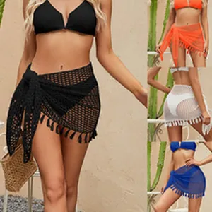Detail of hollow crochet knit beach skirt cover-up with tassels in various colors