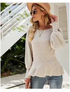 Detail view of a beige peplum knit sweater with lantern sleeves on a model.
