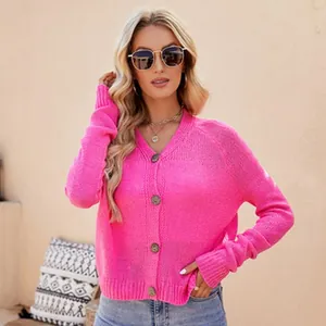 Dettaglio del cardigan in maglia rosa vivace con scollo a V e bottoni