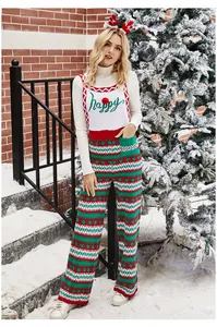 Vue détaillée d'une salopette de Noël en tricot festif avec motifs flocons et broderie 'Happy'.