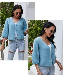 Detail view showing a soft blue V-neck knit cardigan with unique textured finish and buttons
