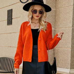 Vista dettagliata di un vivace cardigan in maglia arancione indossato da una modella chic