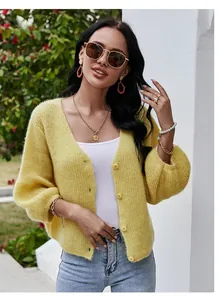 Detail shot of a fuzzy yellow knit cardigan with v-neck and elegant buttons.