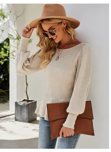 Detailed view of women's beige lantern sleeve knit sweater with a peplum waist