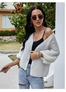 Detail view of a white V-neck knitted cardigan with fluffy texture and buttons.