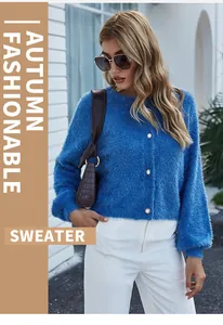 Donna elegante in cardigan di maglia soffice blu e pantaloni bianchi su sfondo urbano