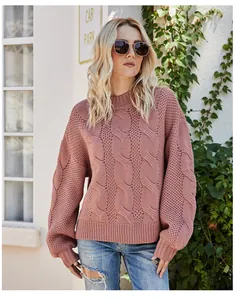 Close-up of a women's dusty pink cable knit mock neck sweater with a vintage texture