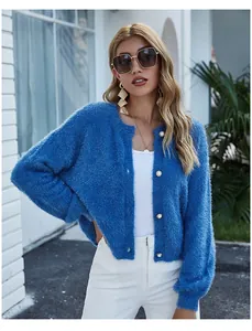 Dettaglio del cardigan in maglia pelosa blu con bottoni decorativi bianchi