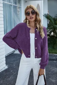 Dettaglio di un morbido cardigan in maglia viola con eleganti bottoni di perla.