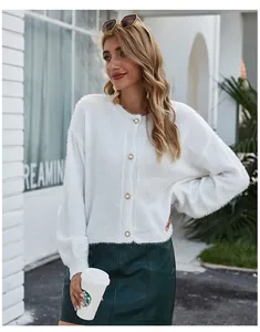 Scatto lifestyle all'aperto di un cardigan in maglia bianco soffice con bottoni dorati