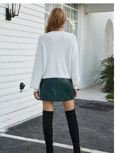 Vista posteriore di un cardigan in maglia bianca a maniche lunghe e vestibilità ampia.