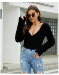Stylish model shot of a black V-neck mohair sweater paired with trendy ripped denim jeans.