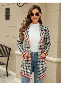 Détail d'une femme portant un long gilet en maille pied-de-poule dans un décor d'automne