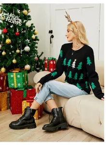 Lifestyle-detail van een zwarte kerstboomgebreide trui in een gezellige vakantiesfeer