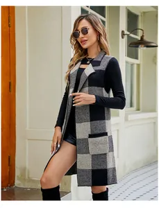 Elegant model posing in long black and grey checkered sleeveless knit vest cardigan