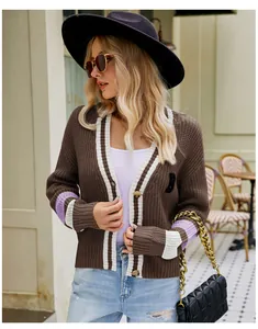 Stylish blonde model wearing a brown preppy V-neck knit cardigan with white striped details