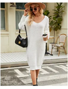 Macro detail of white knitted sweater dress showing honeycomb texture and V-neckline.